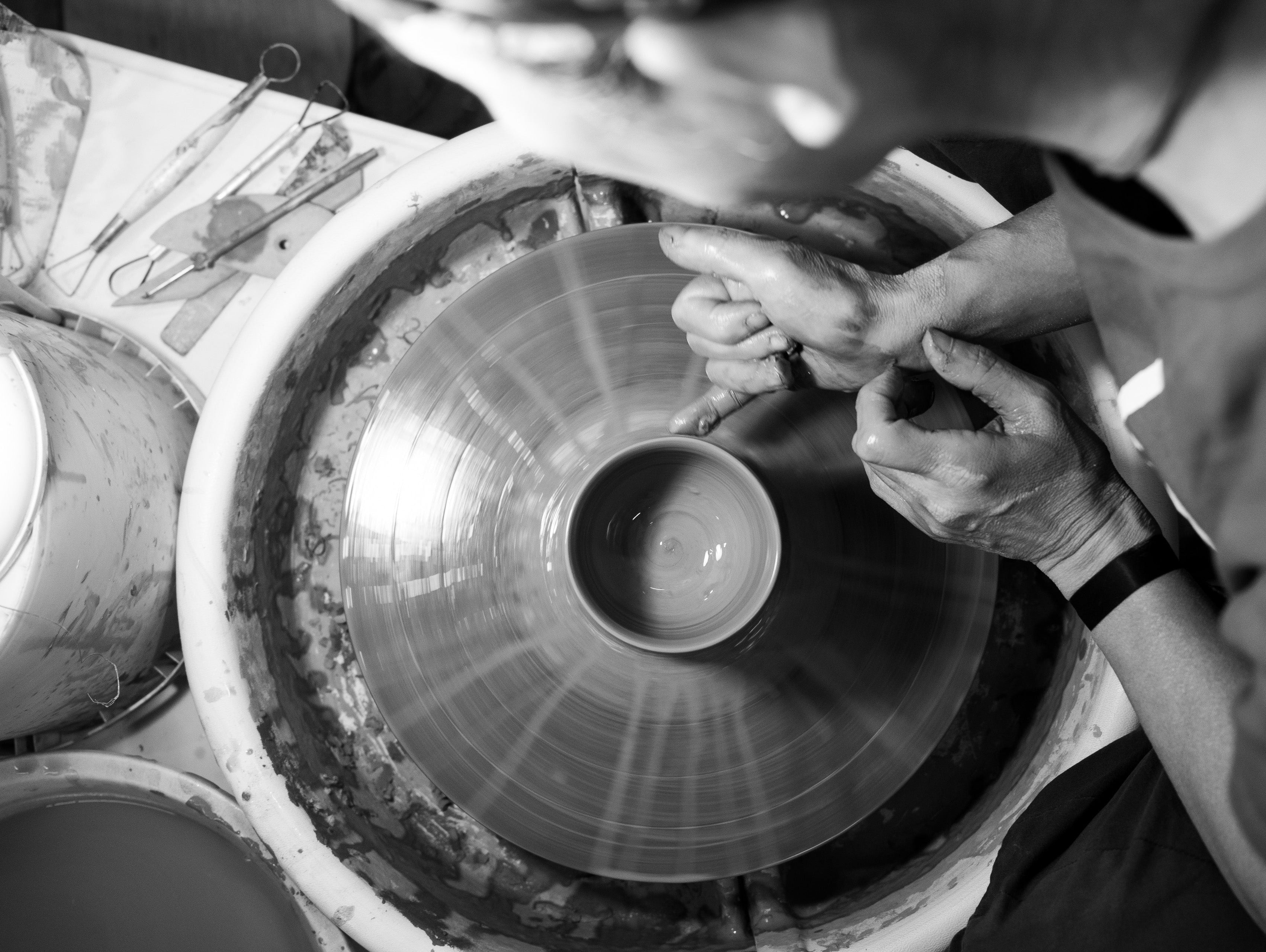 Yukari Hazama hand-throwing a cup on the potter's wheel.