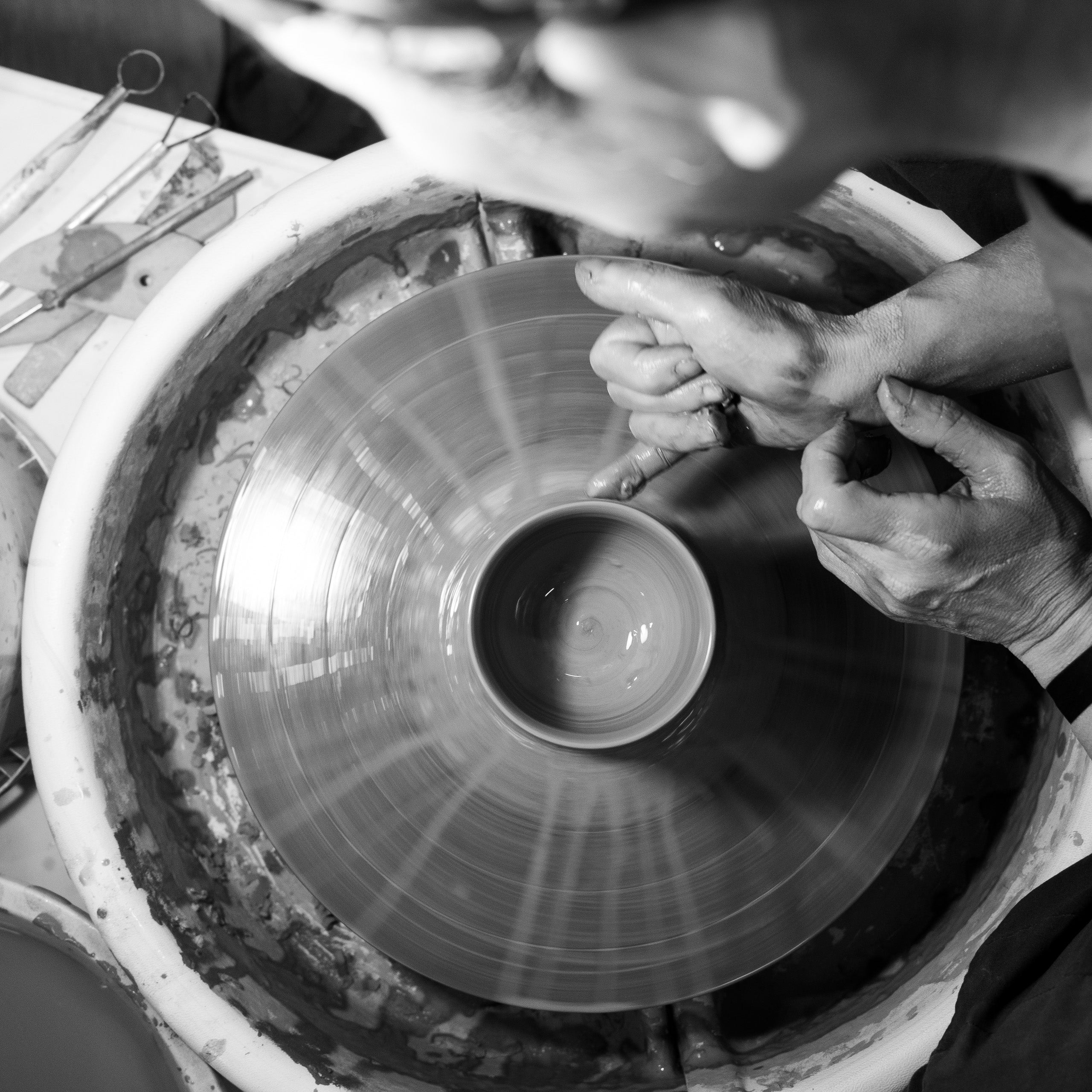 Yukari Hazama hand-throwing a cup on the potter's wheel.