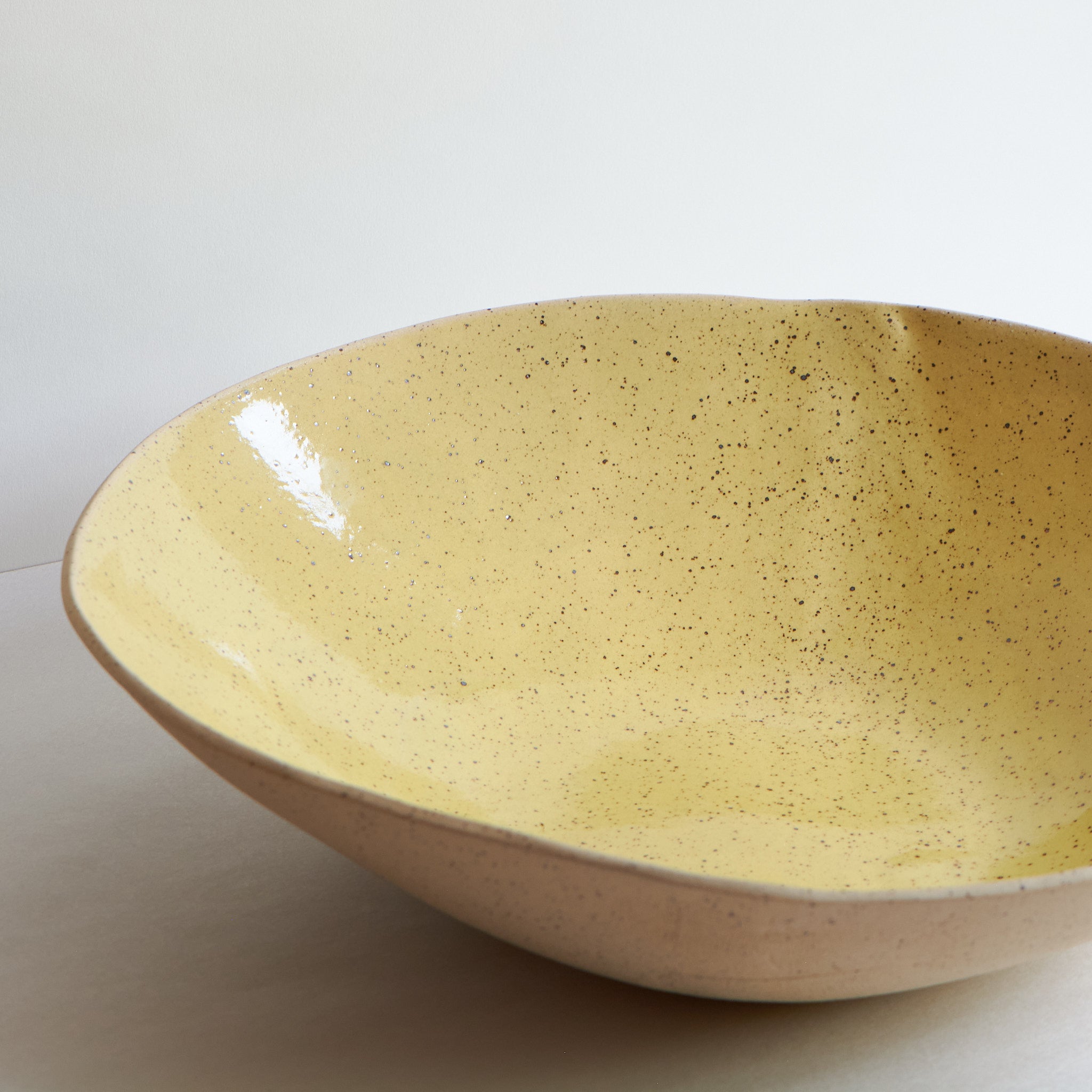 Yellow fruit bowl made of speckled stoneware