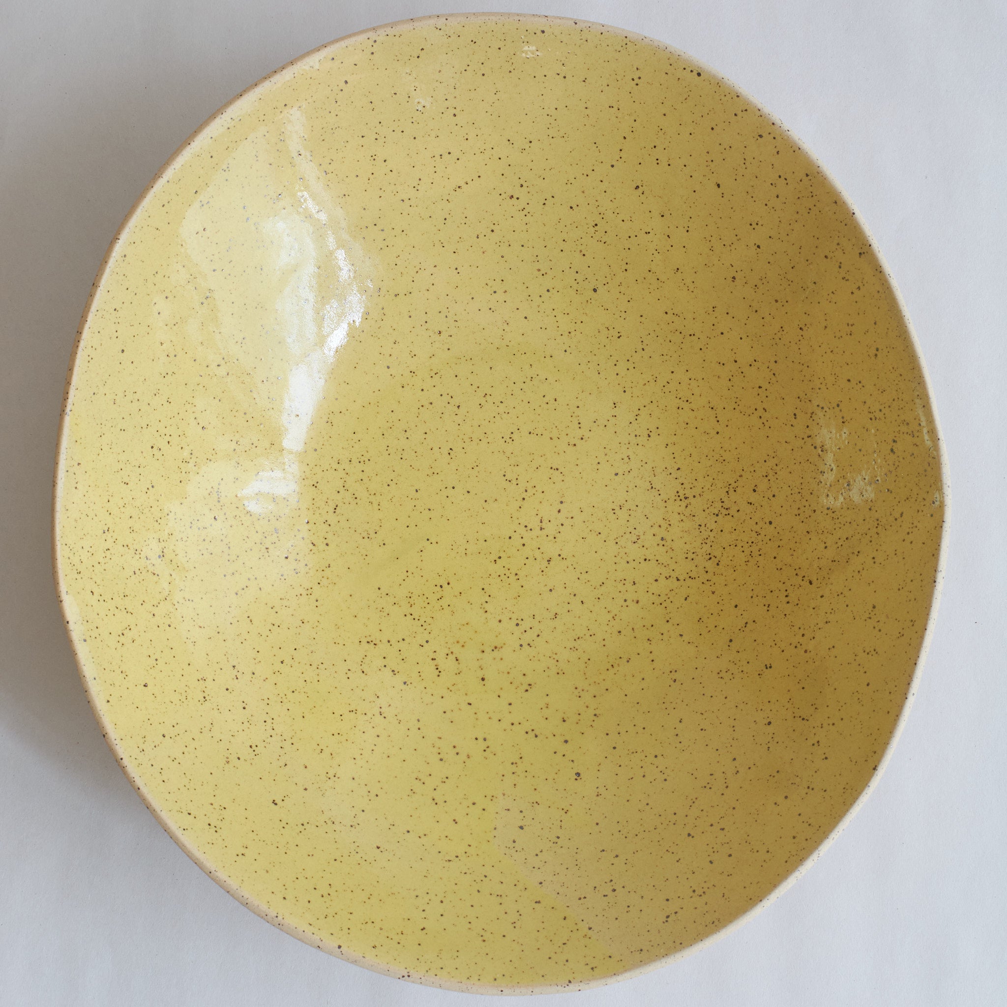 Yellow fruit bowl made of speckled stoneware