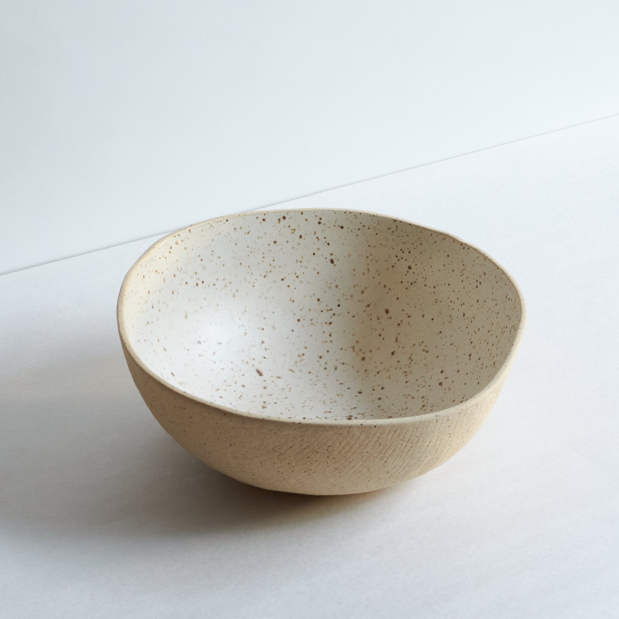 Large off-white bowl made of speckled stoneware