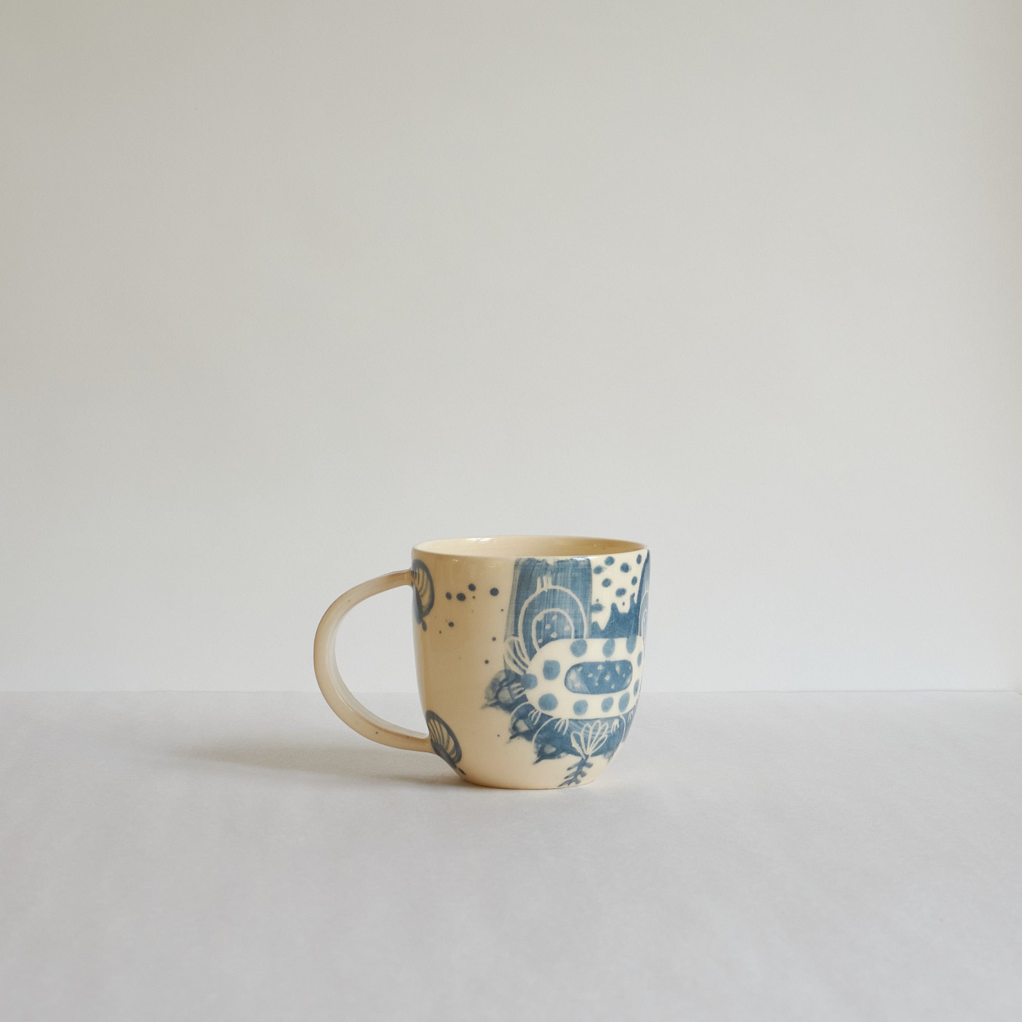 Small blue and white earthenware cup with unique carvings