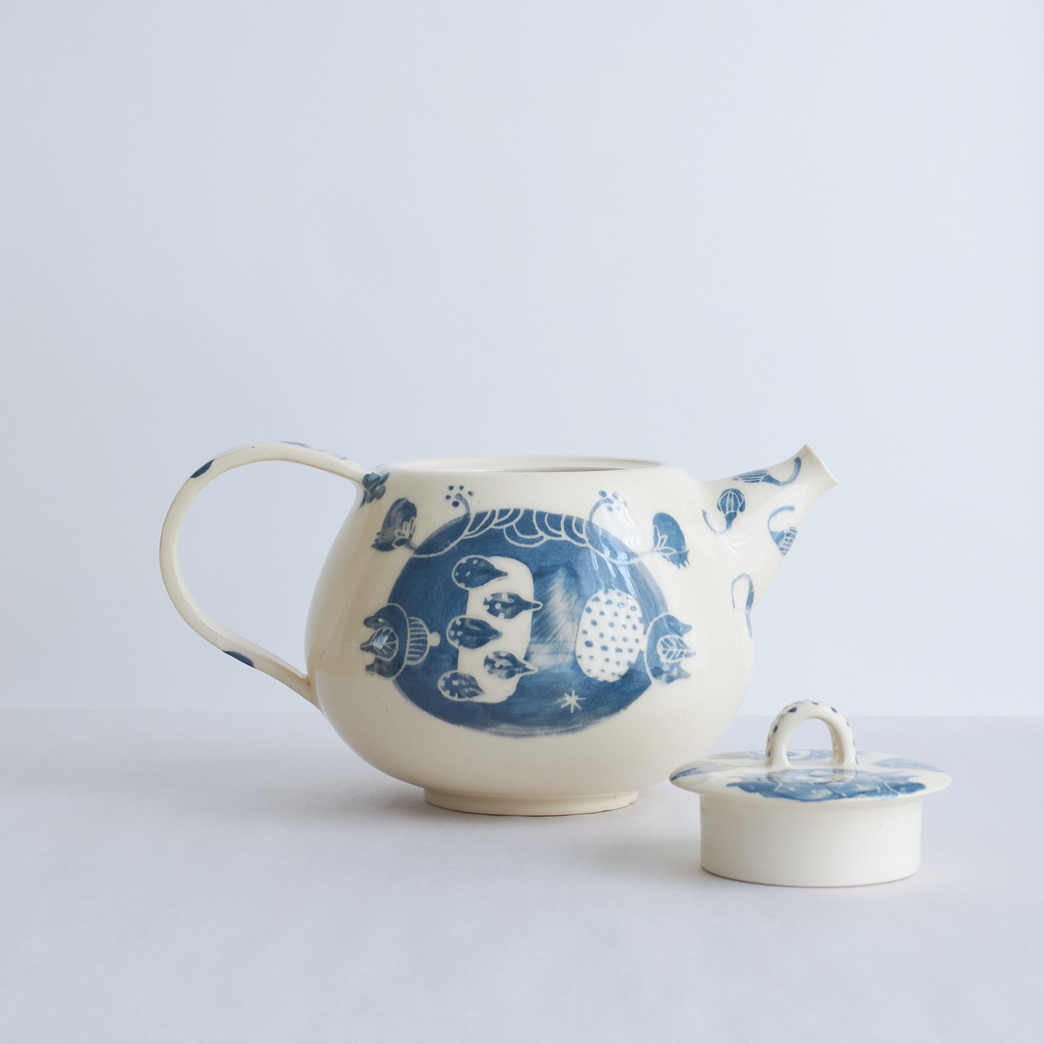 White earthenware teapot with blue carvings
