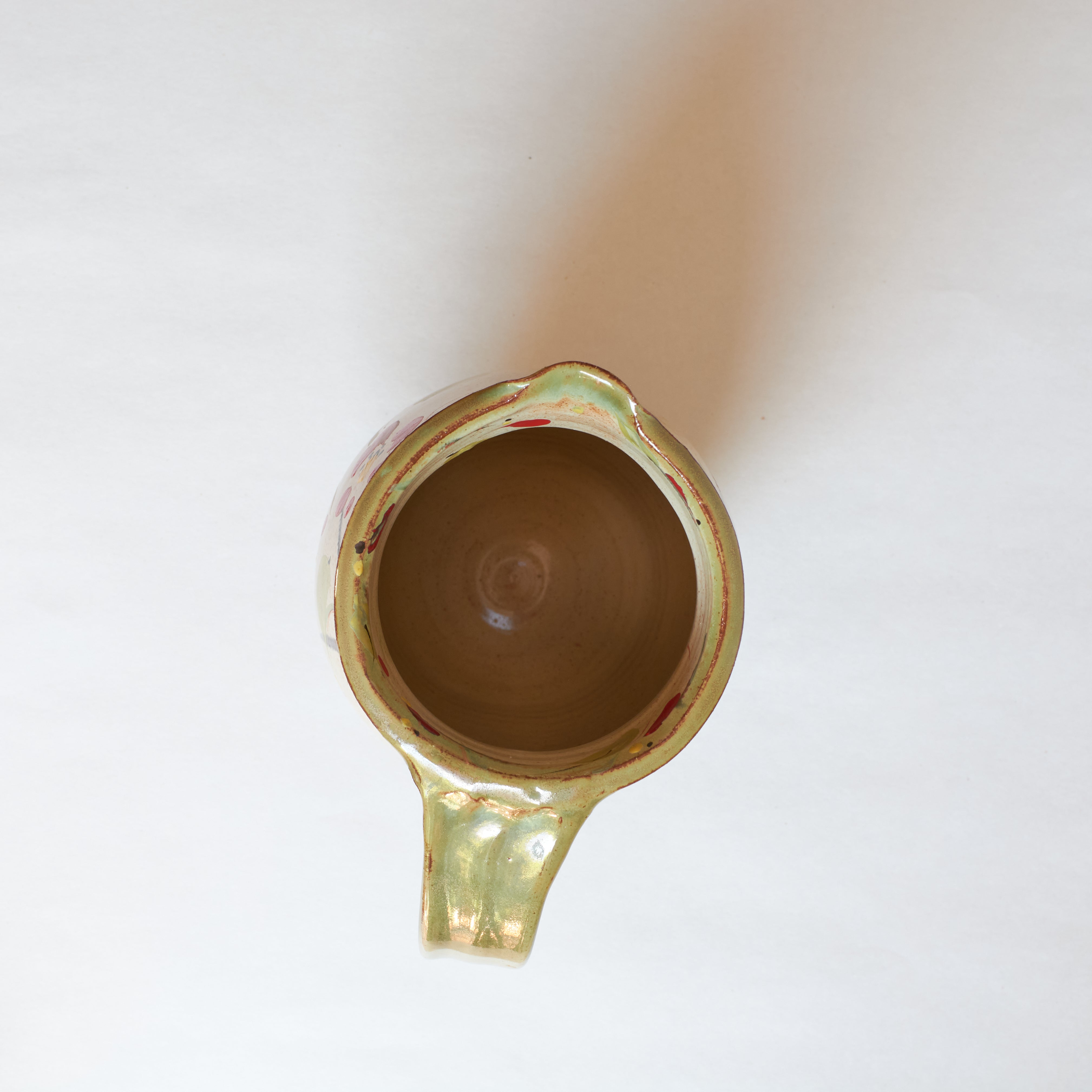 Inside of ceramic pitcher with winter camellia design on a white background