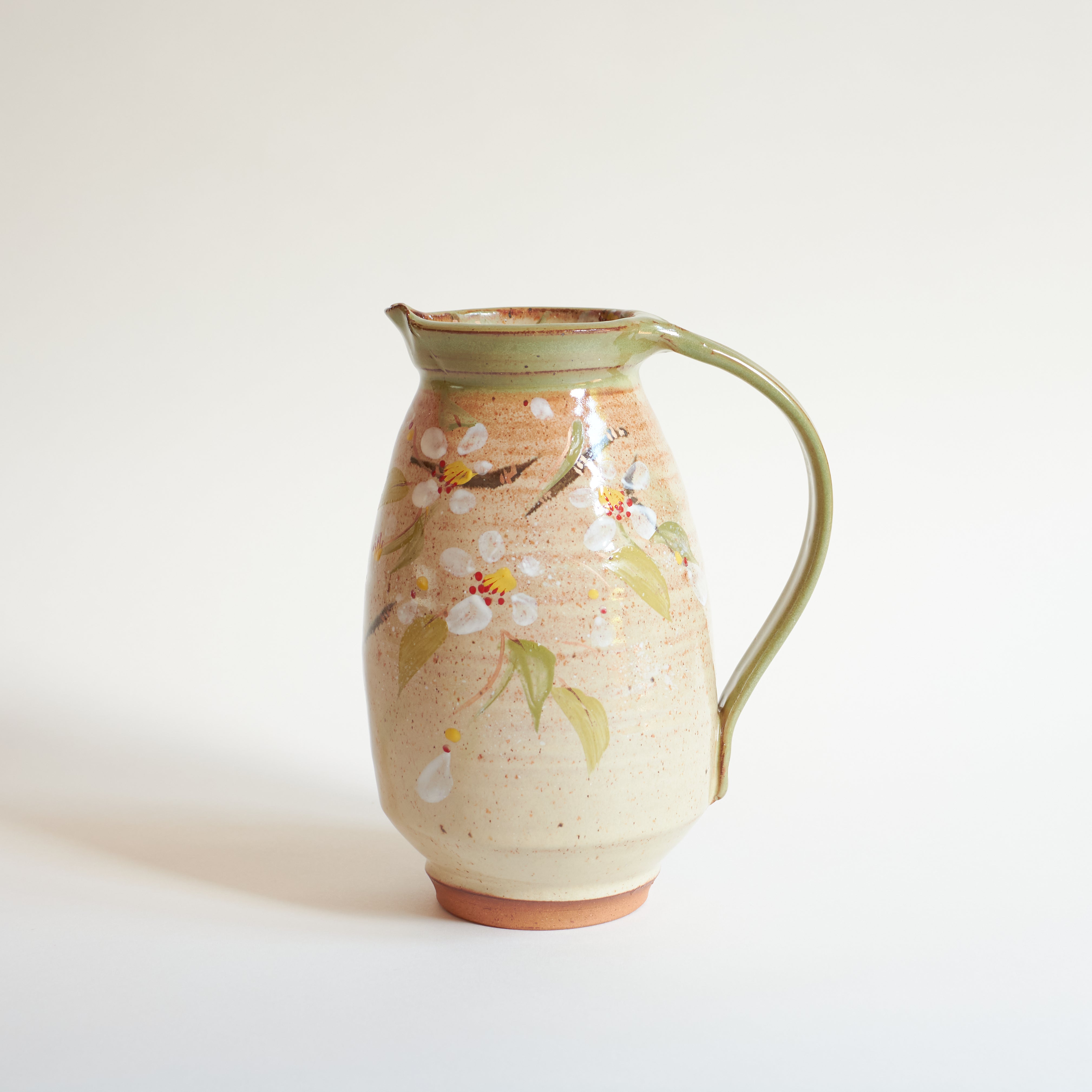 Ceramic pitcher with Japanese spring cherry blossoms design on a white background