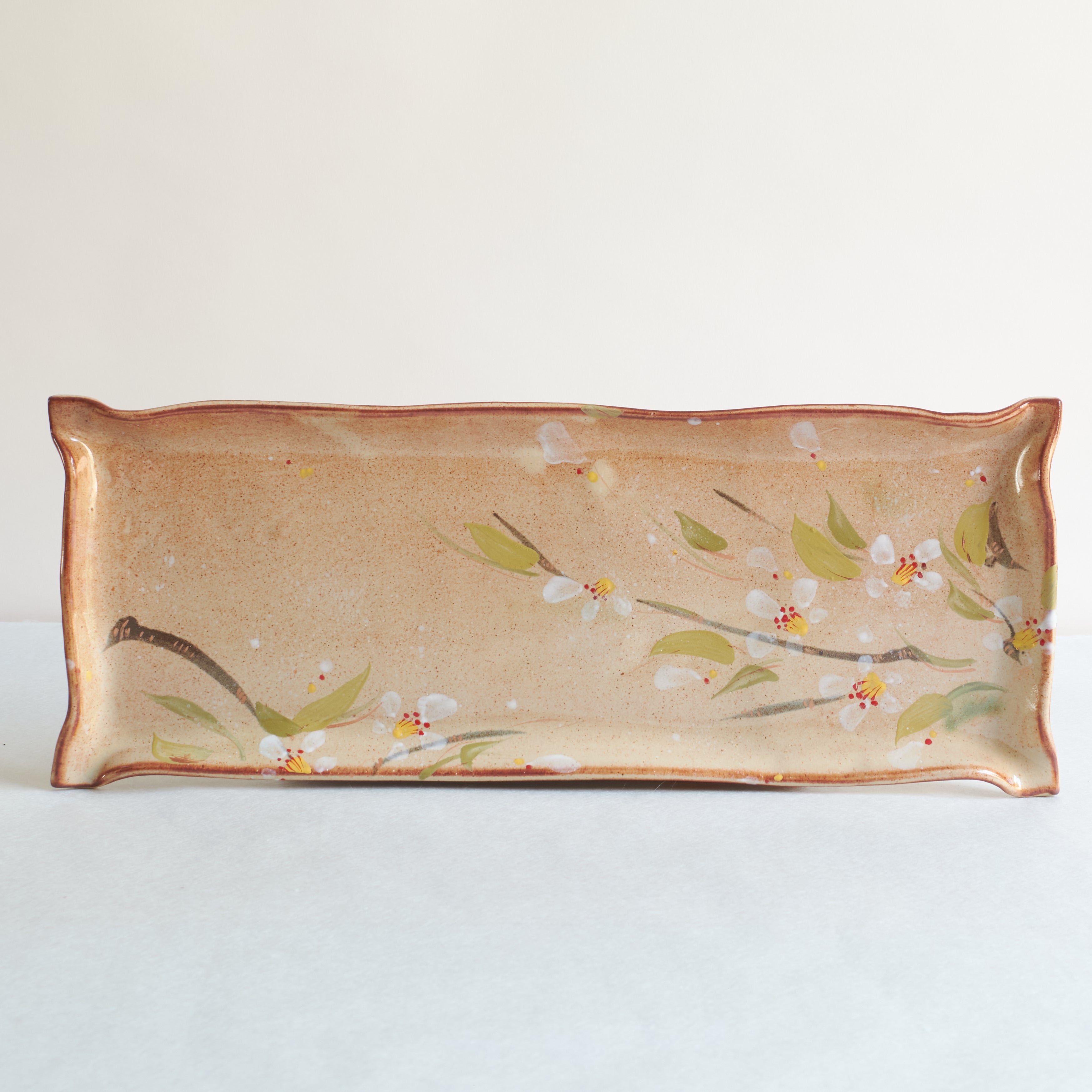 Rectangular ceramic dish with cherry blossom design on a white background