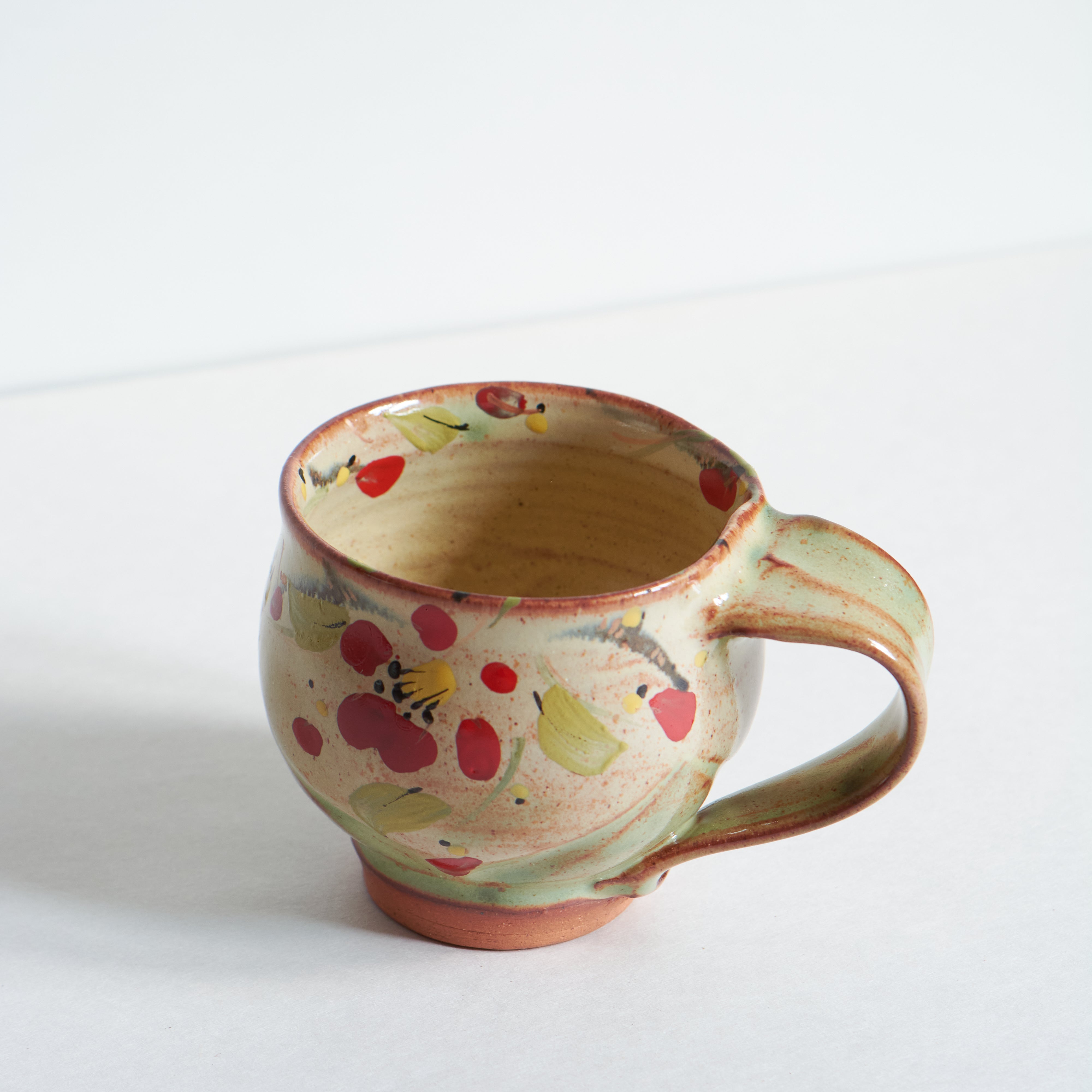 Ceramic mug with red winter camelia design on a white background