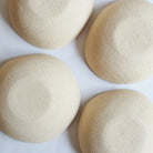 Bottom view of four large off-white bowls made of speckled stoneware 