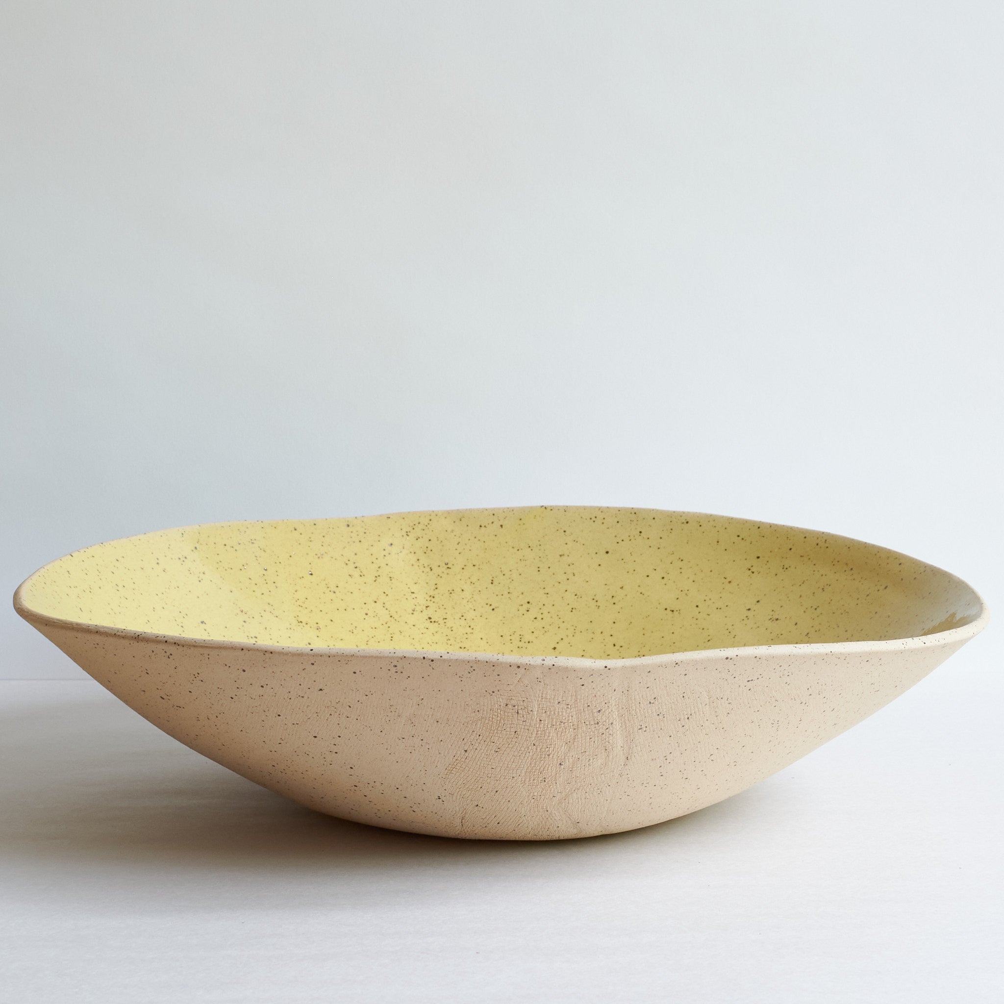 Yellow fruit bowl made of speckled stoneware
