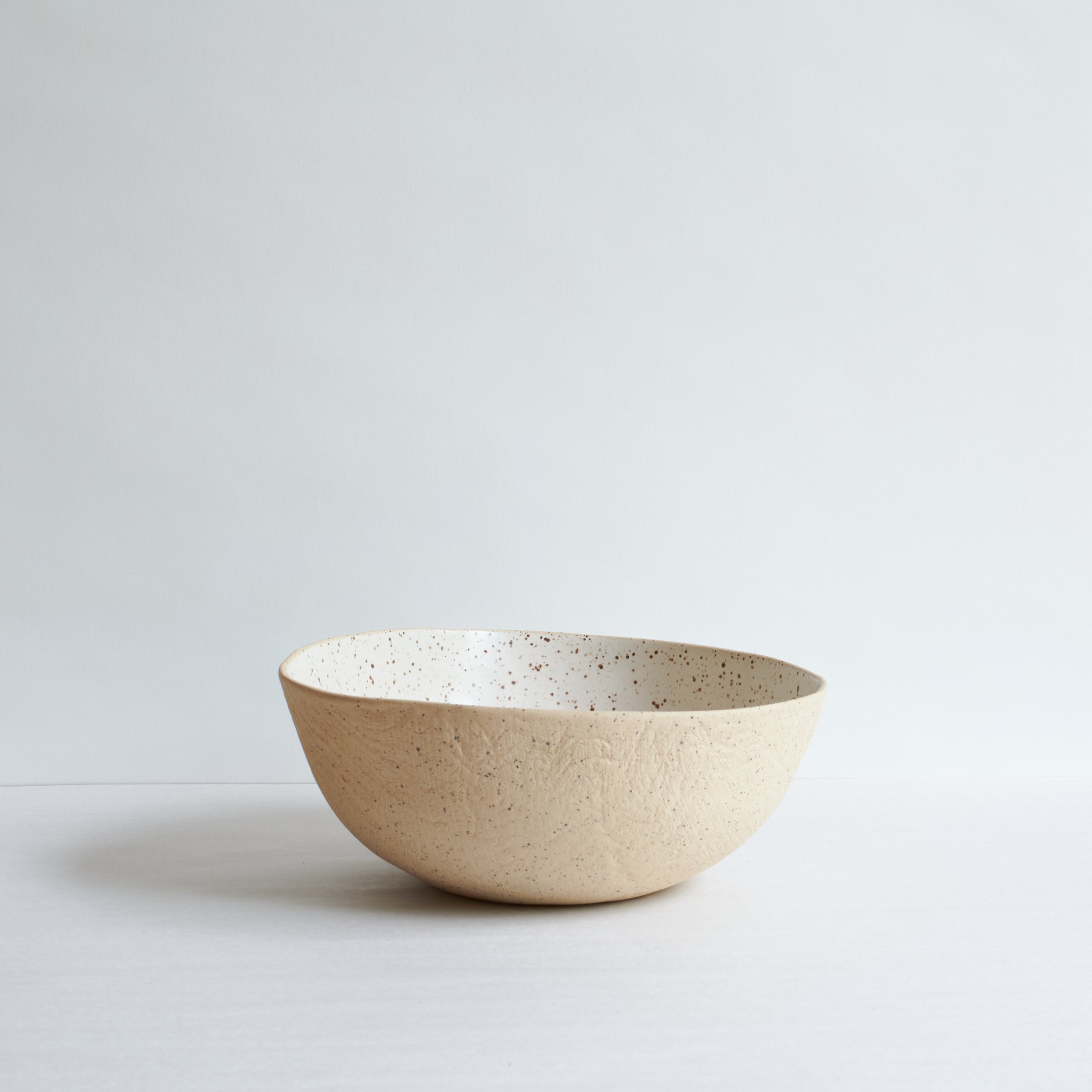Large off-white bowl made of speckled stoneware 
