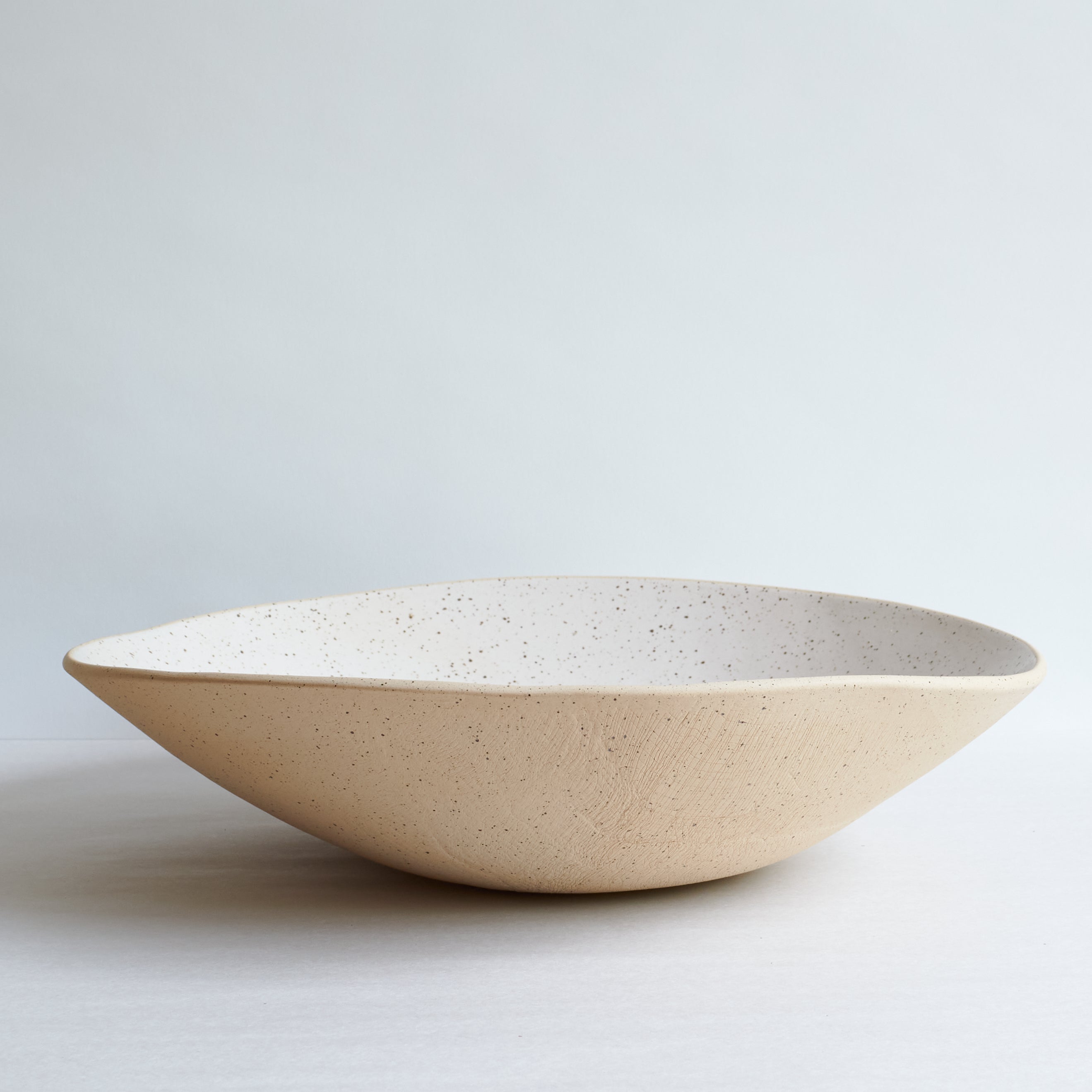 Off-white ceramic bowl on a light gray background