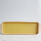 Yellow rectangular serving platter made of speckled stoneware