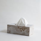 Ceramic tissue box with white tissues on a light gray background