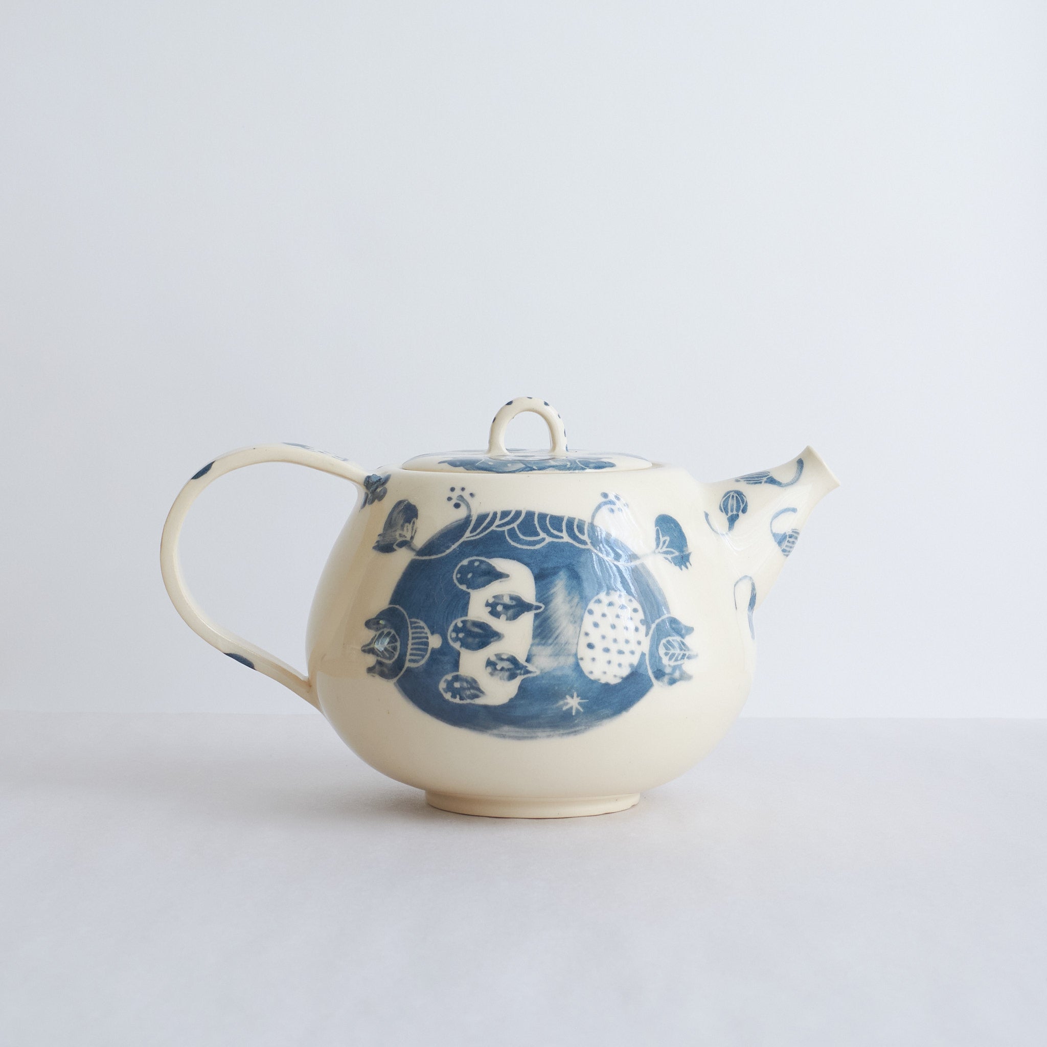 White earthenware teapot with blue carvings