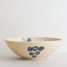 Blue handmade ceramic serving bowl with blue and black decorative carved patterns on a white background