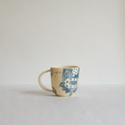 Small blue and white earthenware cup with unique carvings