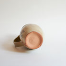 Bottom of ceramic pitcher with winter camellia design on a white background