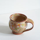 Ceramic mug with Japanese cherry blossom patterns on a white background