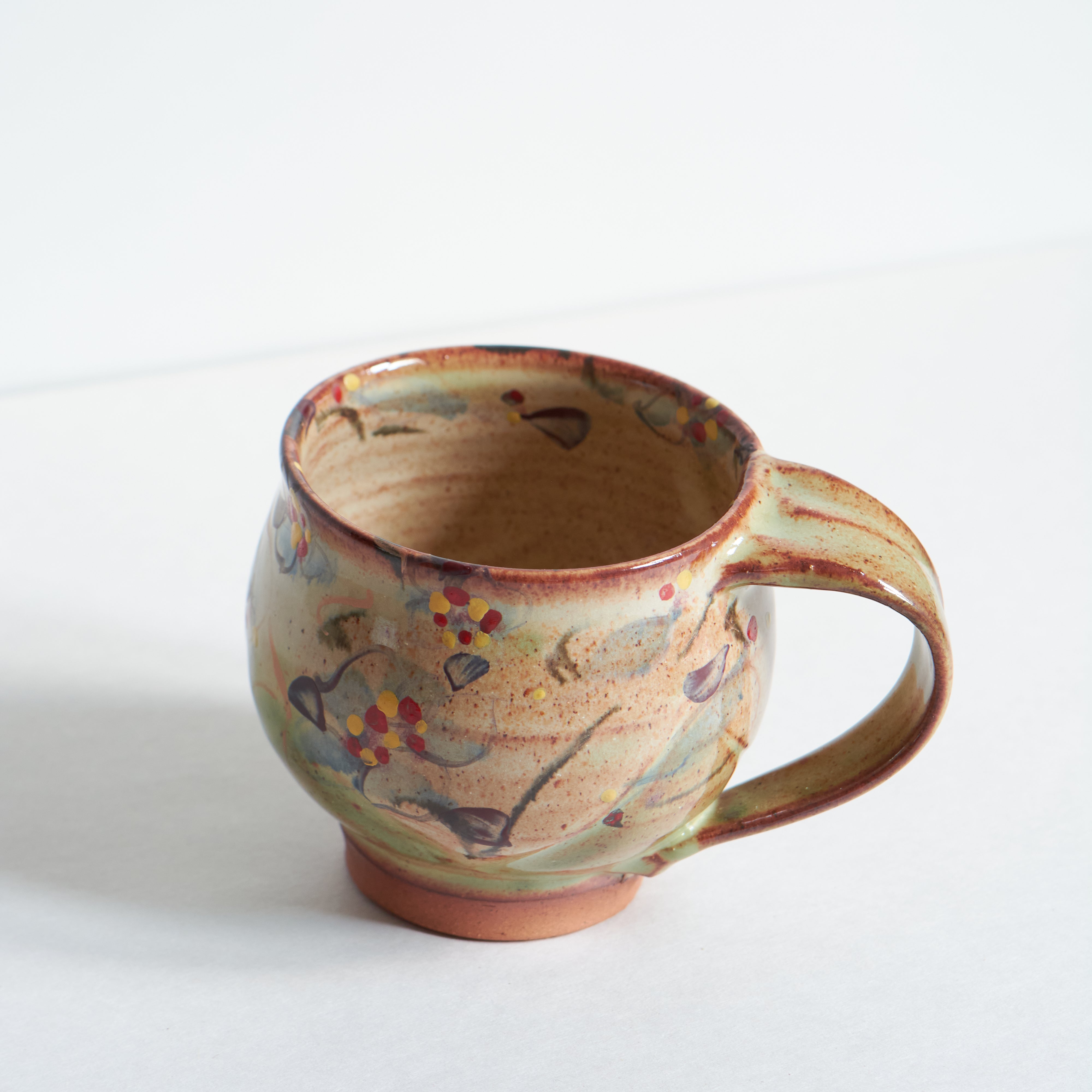 Handmade ceramic mug with purple morning glories design on a white background