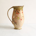Ceramic pitcher with red camelia design on a white background