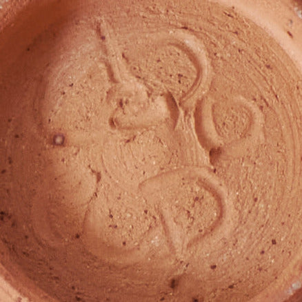 Close-up of a terracotta pot with a logo on the base
