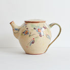 Side view of ceramic teapot with morning glories design on a light background