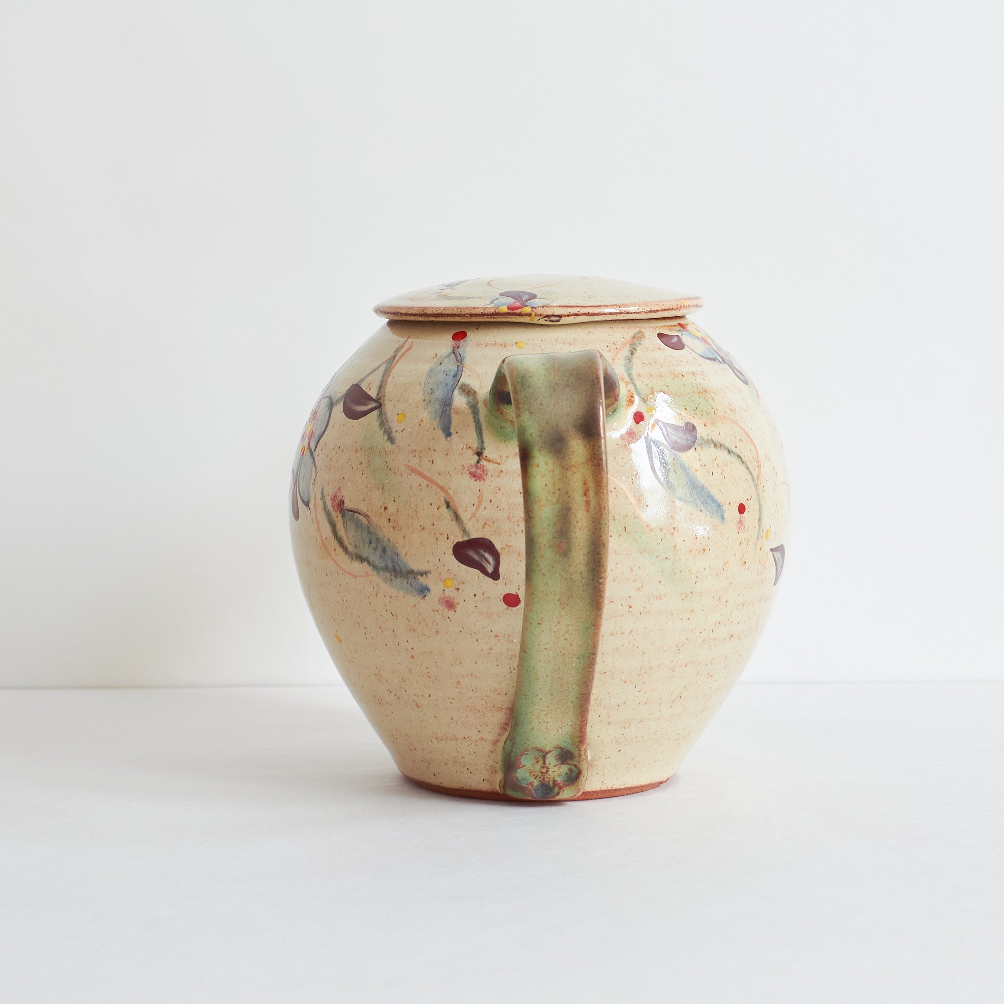 Back  of ceramic teapot with morning glories design on a light background