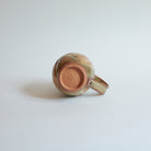 Bottom of ceramic mug on a light gray background.