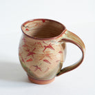 Ceramic mug with Japanese maple tree leaf pattern on a white background