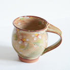 Handmade ceramic mug with Japanese cherry blossom patterns.