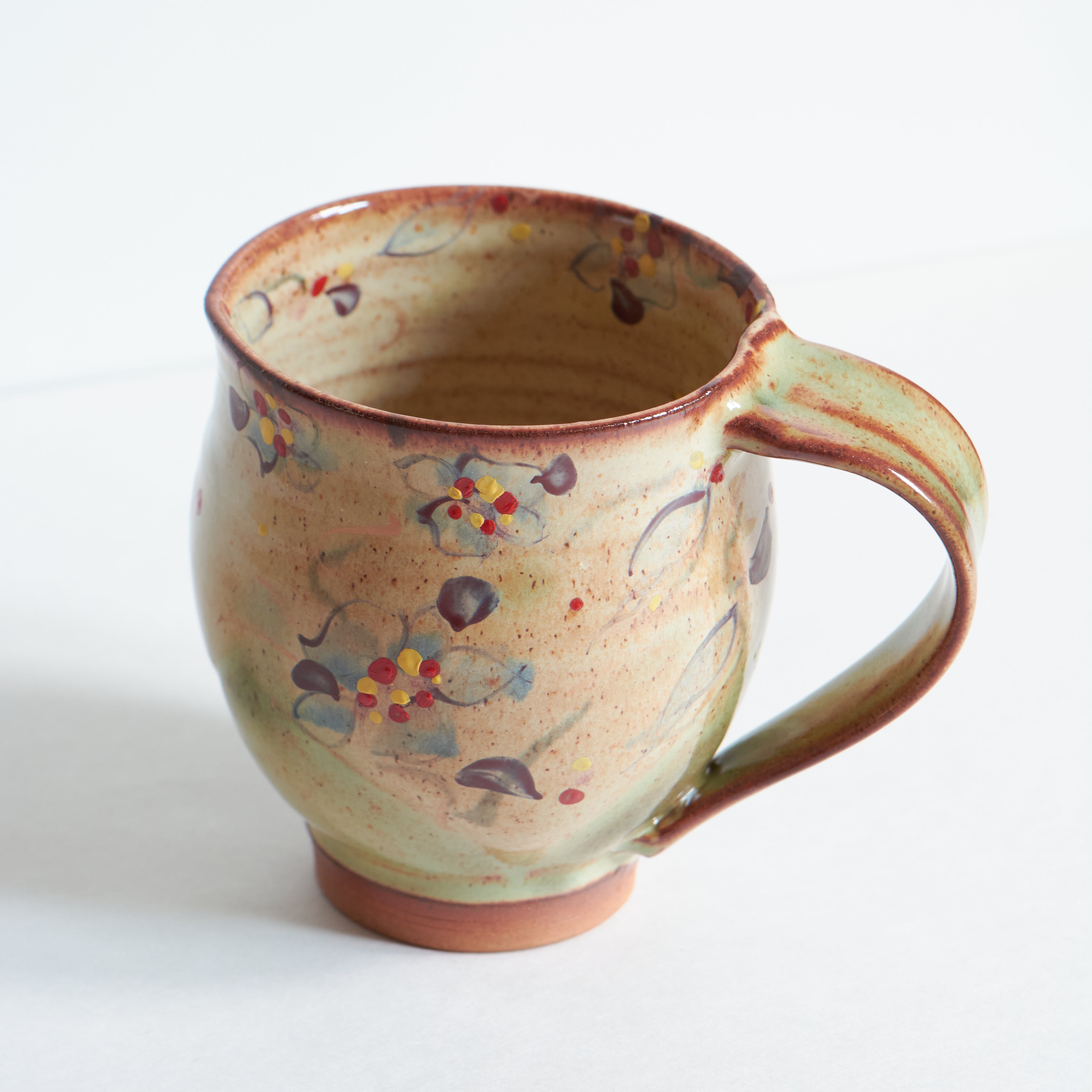 Handmade ceramic mug with purple morning glories patterns on a white background