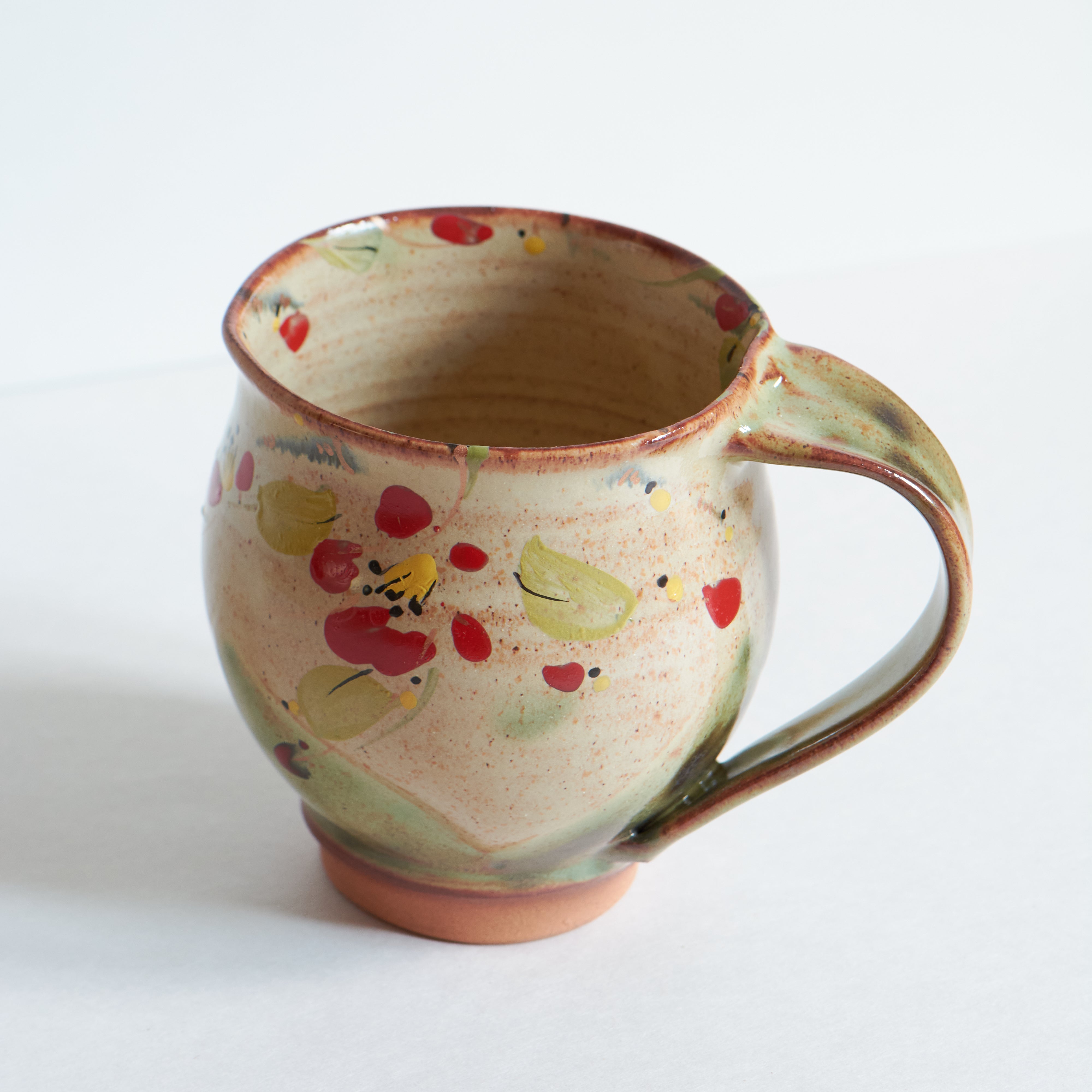 Handmade ceramic mug with wither camelia pattern on a white background