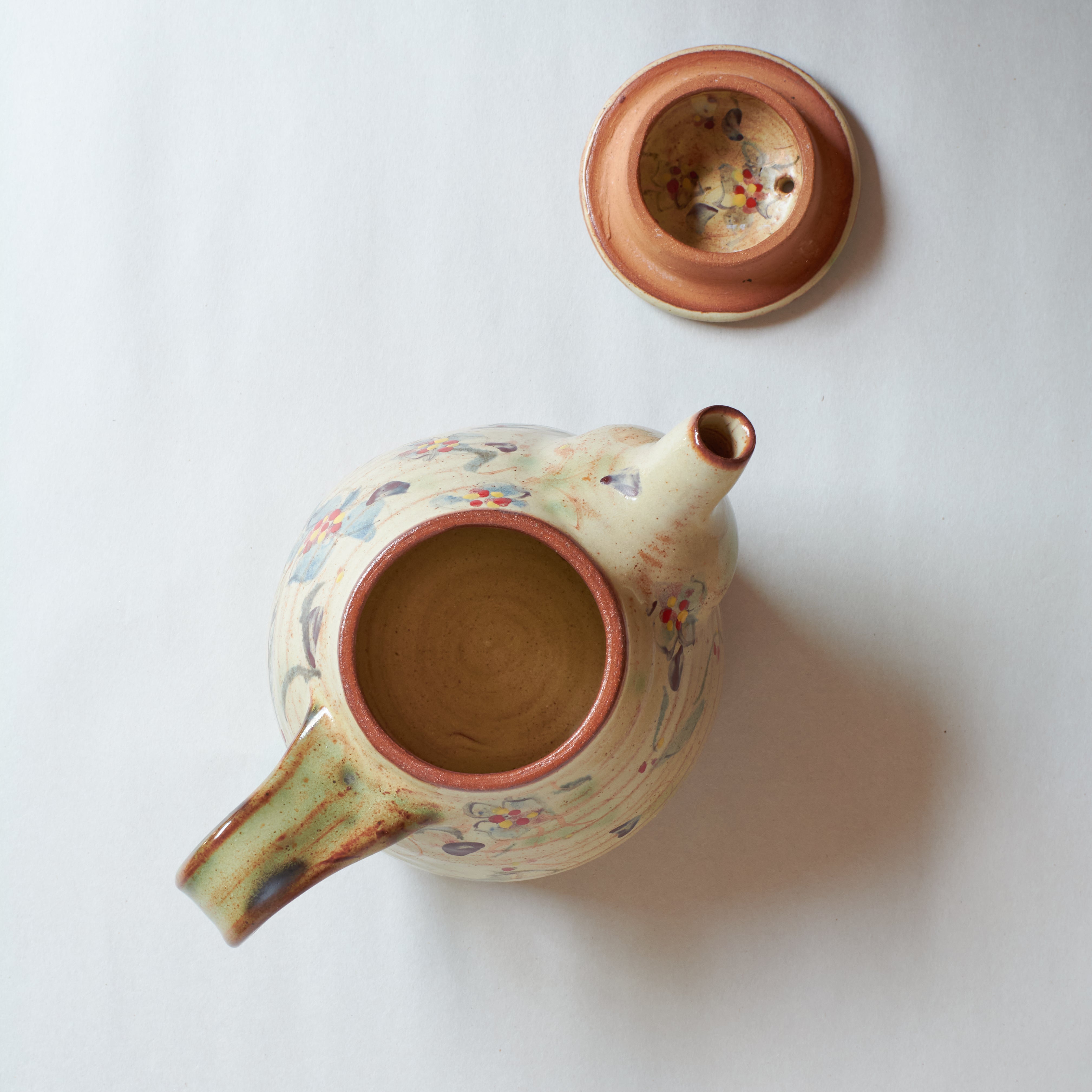 Ceramic teapot with floral patterns on a white background
